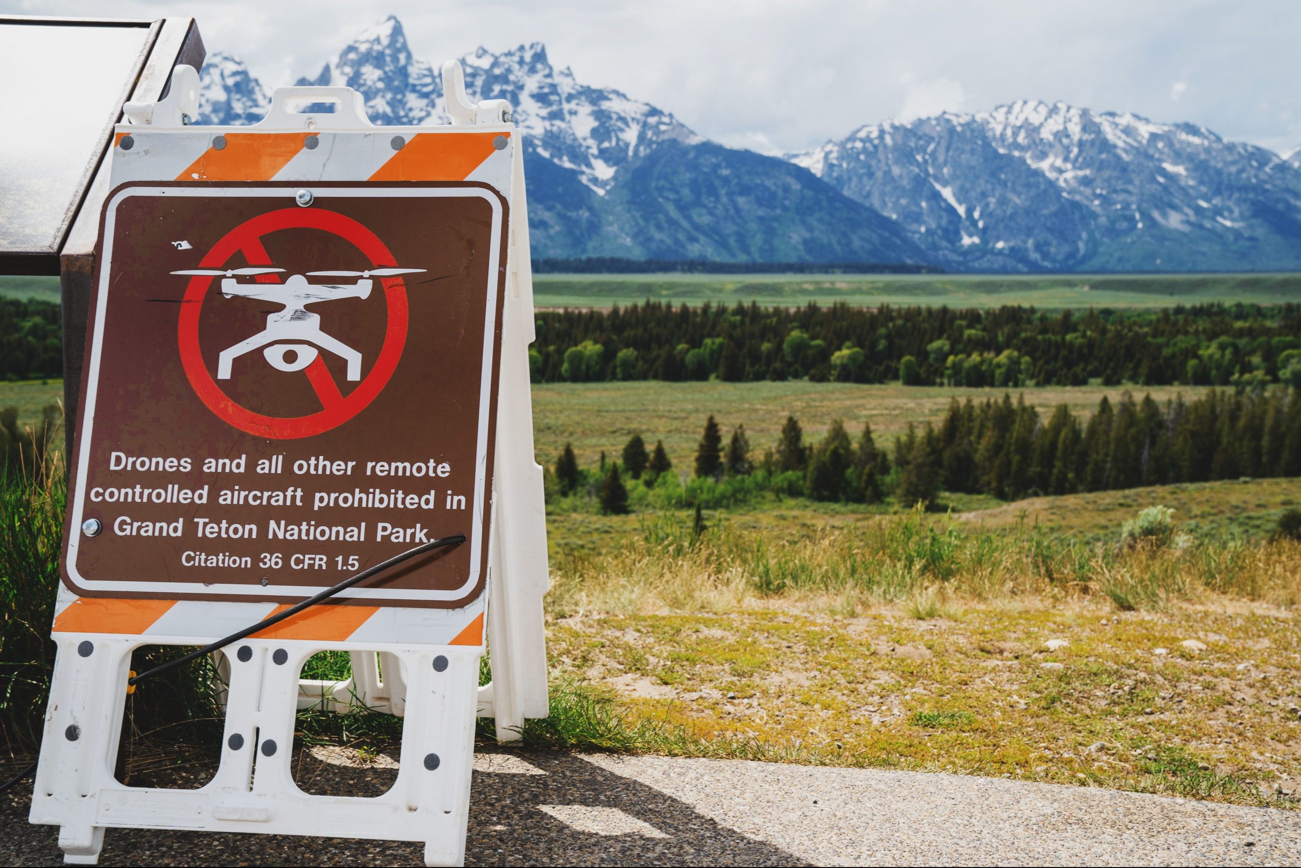Les visiteurs du parc national de Grand Teton sont déchirés par le rupture de règles capturé en utilisant un appareil interdit juste à côté du panneau d'avertissement